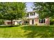 Inviting two-story brick home with white siding, large trees, and a lush green lawn creating curb appeal at 100 Wellington Rd, Indianapolis, IN 46260