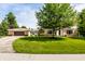 Beautiful brick home featuring an attached garage, a well-manicured lawn and a large tree in the front yard at 100 Wellington Rd, Indianapolis, IN 46260