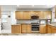 Well-lit kitchen featuring stainless steel appliances, granite countertops, and wood cabinets at 100 Wellington Rd, Indianapolis, IN 46260