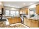 Bright kitchen with granite countertops, tile backsplash, stainless appliances, and natural wood cabinetry at 100 Wellington Rd, Indianapolis, IN 46260