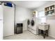 Laundry room with washer, dryer, utility sink, wine fridge, and storage space at 100 Wellington Rd, Indianapolis, IN 46260