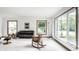 Open-concept living room bathed in natural light, featuring neutral walls, plush carpet, and stylish furnishings at 100 Wellington Rd, Indianapolis, IN 46260