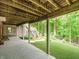 Covered patio offers an outdoor entertaining space that leads to a lush green lawn and wooded area at 10350 Courageous Dr, Indianapolis, IN 46236
