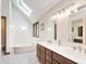 Bright bathroom with dual sinks, soaking tub, skylight, and neutral finishes at 10350 Courageous Dr, Indianapolis, IN 46236