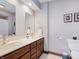 Bathroom featuring dual sinks, wood cabinets, and a shower-tub combination at 10350 Courageous Dr, Indianapolis, IN 46236