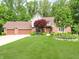 Beautiful brick home featuring an attached three car garage and mature landscaping at 10350 Courageous Dr, Indianapolis, IN 46236