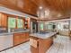 Kitchen with a center island with a cooktop, wooden cabinets, stainless steel appliances, and an adjacent dining area at 10350 Courageous Dr, Indianapolis, IN 46236