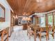 A well-lit kitchen features white tiled floors, a wooden ceiling, cabinets, and an island with barstool seating at 10350 Courageous Dr, Indianapolis, IN 46236