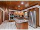 Spacious kitchen with wood cabinets, granite countertops, a center island with a cooktop and stainless steel appliances at 10350 Courageous Dr, Indianapolis, IN 46236
