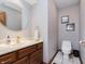 A tidy powder room features a mirror, a vanity with gold fixtures, and a toilet at 10350 Courageous Dr, Indianapolis, IN 46236