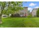 Wide shot of the backyard with trees, a deck with seating, and well manicured green lawn at 11872 Traymoore Dr, Fishers, IN 46038