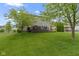 Wide shot of the backyard with trees, a deck with seating, and well manicured green lawn at 11872 Traymoore Dr, Fishers, IN 46038