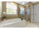 Well-lit bathroom featuring a soaking tub, glass-enclosed shower, and tiled accents at 11872 Traymoore Dr, Fishers, IN 46038