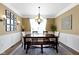 Formal dining room boasting wainscoting, elegant chandelier, and seating for six at 11872 Traymoore Dr, Fishers, IN 46038