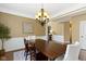 Elegant dining area with wainscoting, dark wood table, and modern chandelier at 11872 Traymoore Dr, Fishers, IN 46038