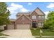Inviting two-story brick home featuring a three car garage and well-manicured lawn at 11872 Traymoore Dr, Fishers, IN 46038