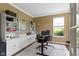 Well-lit home office features built-in shelving, neutral paint and large window at 11872 Traymoore Dr, Fishers, IN 46038