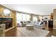 Open-concept living room with a fireplace, large rug and view into the adjacent kitchen at 11872 Traymoore Dr, Fishers, IN 46038