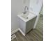 Modern bathroom sink with cabinet and stylish chrome faucet, complemented by gray wood-look flooring at 1322 S Belmont Ave, Indianapolis, IN 46221