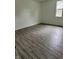 Spacious bedroom with gray laminate flooring, white walls, and a window providing natural light at 1322 S Belmont Ave, Indianapolis, IN 46221