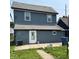 Two-story home with gray siding, white trim, well-maintained lawn, and concrete patio in the backyard at 1322 S Belmont Ave, Indianapolis, IN 46221