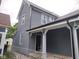 Gray home featuring vinyl siding, white trim, covered entryway, and well-maintained gutters at 1322 S Belmont Ave, Indianapolis, IN 46221