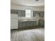 Updated kitchen with gray cabinets, white appliances and gray wood-look flooring at 1322 S Belmont Ave, Indianapolis, IN 46221