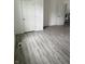 Bright living room with light gray laminate flooring, crisp white walls, and two white doors at 1322 S Belmont Ave, Indianapolis, IN 46221