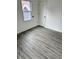 Empty room showcasing gray wood-look flooring and white walls and trim at 1322 S Belmont Ave, Indianapolis, IN 46221