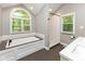 This bathroom features a soaking tub, and a glass shower, all next to large picture windows at 13300 Fairwood Dr, McCordsville, IN 46055