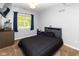 A modern bedroom with dark bedding, gray walls and wood flooring with a large window at 13300 Fairwood Dr, McCordsville, IN 46055