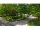 Long, curved driveway leading to a charming ranch-style home surrounded by trees at 13300 Fairwood Dr, McCordsville, IN 46055