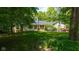 Charming ranch-style home with stone accents and a lush front yard, nestled in a wooded area at 13300 Fairwood Dr, McCordsville, IN 46055