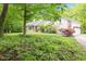 Scenic view of a ranch-style home nestled among mature trees and lush greenery at 13300 Fairwood Dr, McCordsville, IN 46055