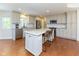 Bright kitchen features white cabinets, stainless steel appliances, and a large granite island with bar seating at 13300 Fairwood Dr, McCordsville, IN 46055