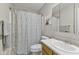 A bathroom with a shower with floral shower curtain, mirror, and single vanity at 1431 Evergreen Dr, Greenfield, IN 46140