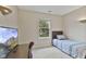 Comfortable bedroom with a bed, desk, and TV; brightened by natural light from a window overlooking the yard at 1431 Evergreen Dr, Greenfield, IN 46140