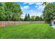 Spacious backyard with lush green grass, a wood fence, and mature trees offering privacy and a serene outdoor setting at 14638 Deerwood Dr, Carmel, IN 46033