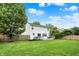 Backyard view showcases a well-maintained lawn, a wooden fence, mature trees, and a deck, creating a private oasis at 14638 Deerwood Dr, Carmel, IN 46033