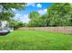 Lush backyard features a large grassy area, mature trees, and a wooden privacy fence, creating a serene outdoor space at 14638 Deerwood Dr, Carmel, IN 46033