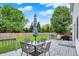 Deck with outdoor dining set, grill, and umbrella offering outdoor enjoyment surrounded by a lush green lawn at 14638 Deerwood Dr, Carmel, IN 46033