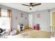 This bedroom features neutral walls, carpet flooring, a ceiling fan, and plenty of play space with natural light at 14638 Deerwood Dr, Carmel, IN 46033