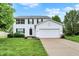 Charming two-story home with a well-manicured lawn and attached two-car garage at 14638 Deerwood Dr, Carmel, IN 46033