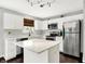Well-lit kitchen with stainless steel appliances, white cabinetry, countertop space, and dark hardwood floors at 14638 Deerwood Dr, Carmel, IN 46033
