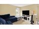 Cozy living room features a large blue couch, a window, a television, and neutral-toned walls at 14638 Deerwood Dr, Carmel, IN 46033