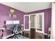 Office area with dual monitors on a desk, purple walls, hardwood flooring, and mirrored french doors at 14638 Deerwood Dr, Carmel, IN 46033