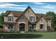 Stunning brick two-story home boasts a stone entryway, arched windows, detailed trim, and a welcoming front porch at 1475 Old Hickory Ln, Westfield, IN 46074