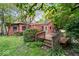 Home exterior features a cozy wooden deck amidst lush greenery and mature trees at 1497 Clinton St, Noblesville, IN 46060