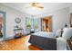 Cozy bedroom features wood floors, a ceiling fan, and a chair by the corner windows at 1497 Clinton St, Noblesville, IN 46060