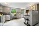 Retro kitchen with checkered wallpaper, stainless steel appliances, and a view of the backyard at 1497 Clinton St, Noblesville, IN 46060